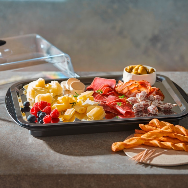 Plateau de fromages, charcuterie, olives et gressins. Repas savoureux.