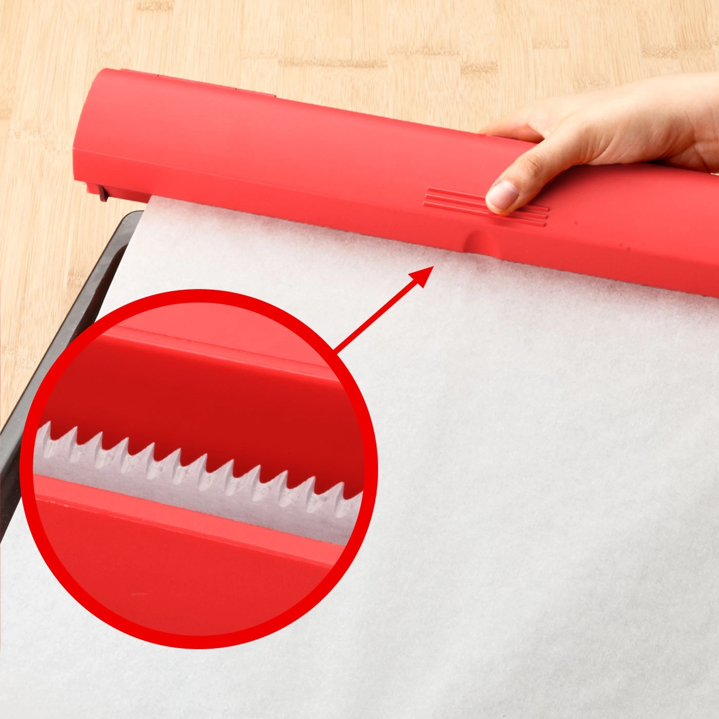 Roter Folienabroller mit gezahntem Messer, Backpapier, Nahaufnahme, Hand