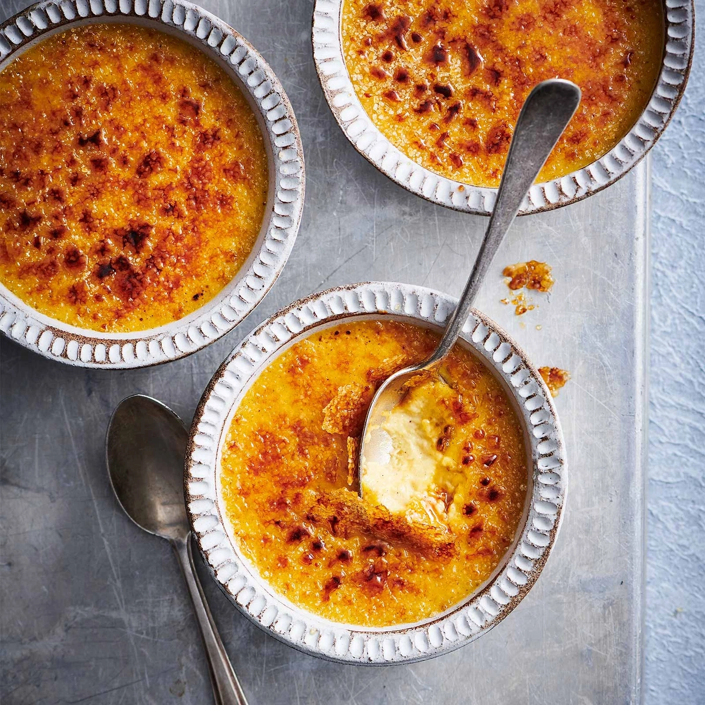 Creme Brulee in Schalen, mit Löffeln, Nahaufnahme, Dessert, Karamellisiert, lecker