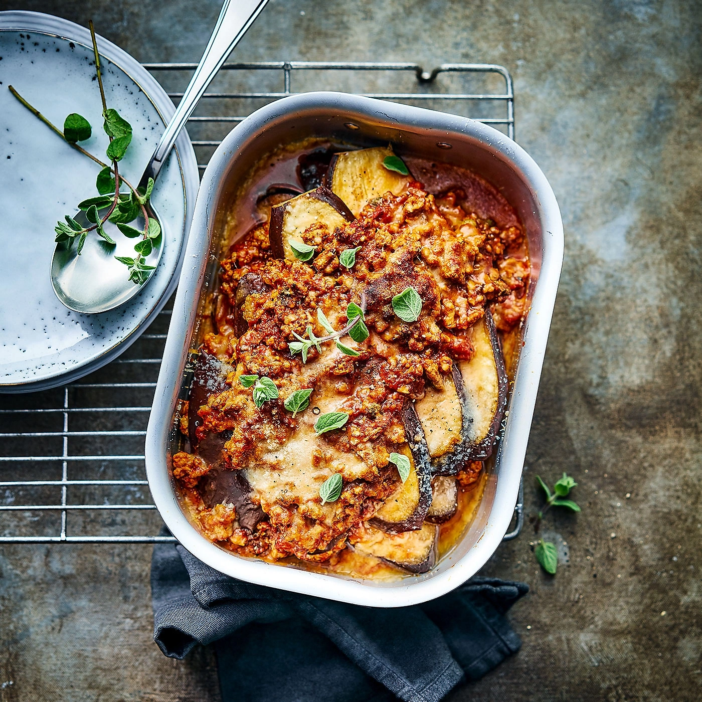 Plat de lasagnes aux aubergines, tomates et herbes, servi dans un plat