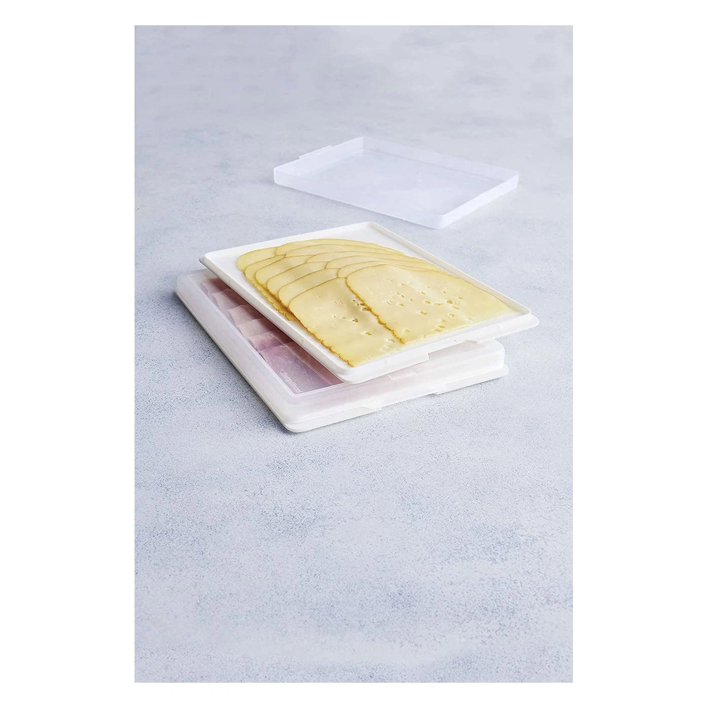 Tranches de fromage dans un récipient blanc sur fond clair. Nourriture.