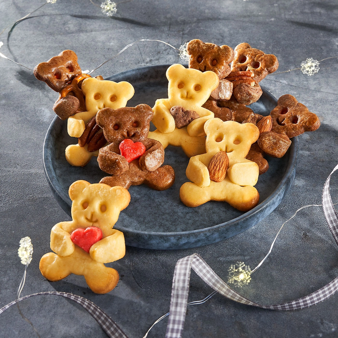 Biscuits en forme d'ours avec des coeurs et des noix sur une assiette décorative.
