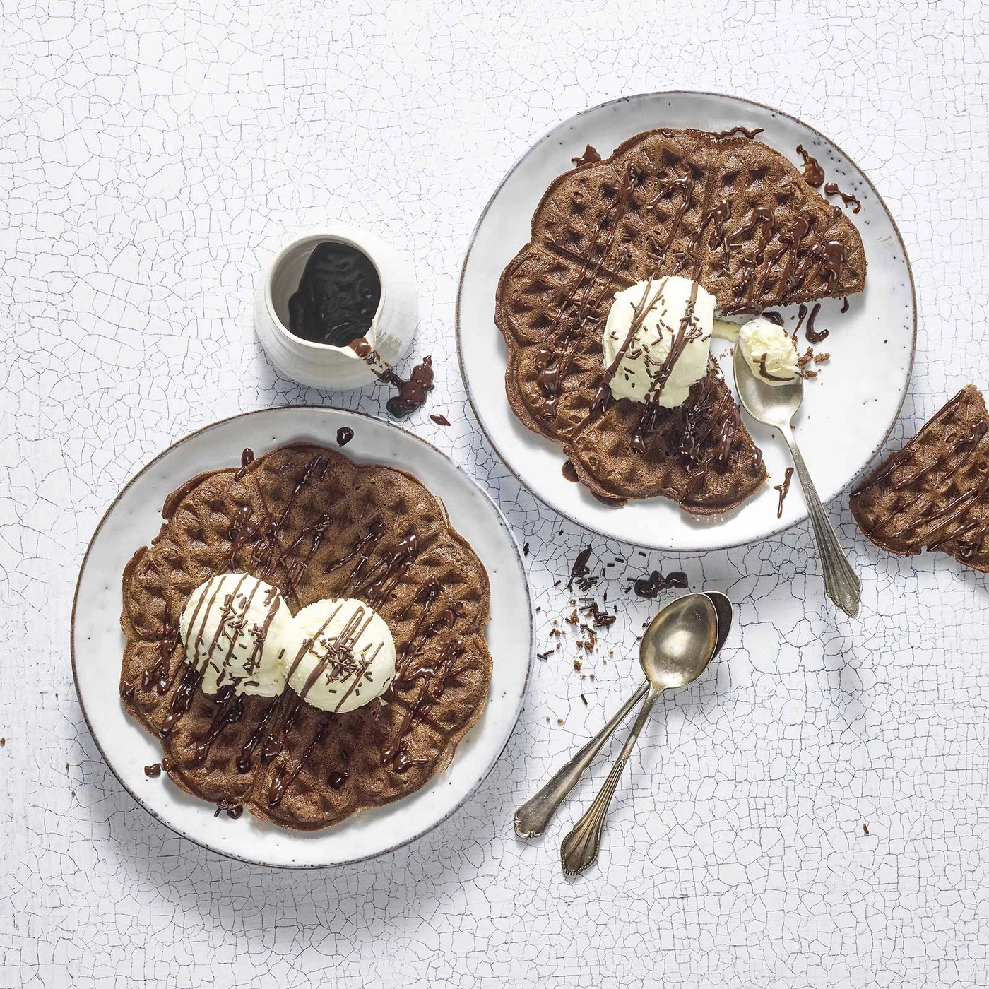 Schokoladenwaffeln mit Eis und Schokosauce auf weißem Tisch