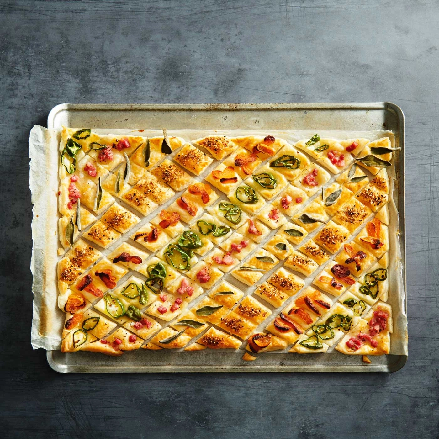 Köstliche, rechteckige Pizza mit verschiedenen Belägen auf einem Backblech.