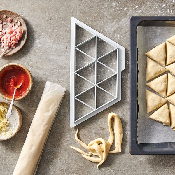 Ingrédients pour triangles de pizza : pâte, sauce tomate, fromage, jambon, plaque, emporte-pièce.