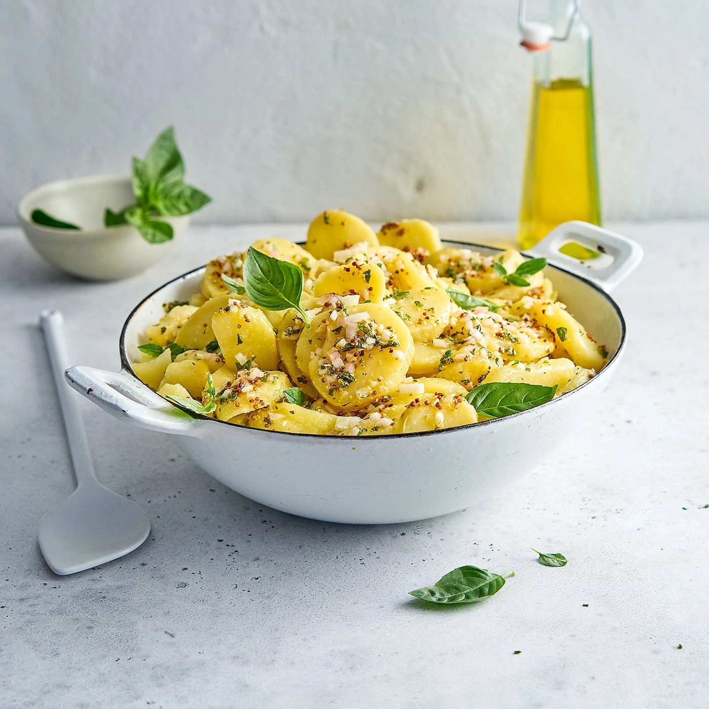 Kartoffelsalat mit frischen Kräutern und Basilikum in einer Schüssel.