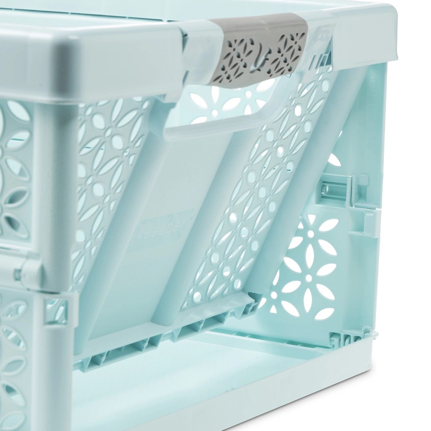 Une étagère de rangement pliable bleu clair avec des motifs floraux perforés et une poignée grise.