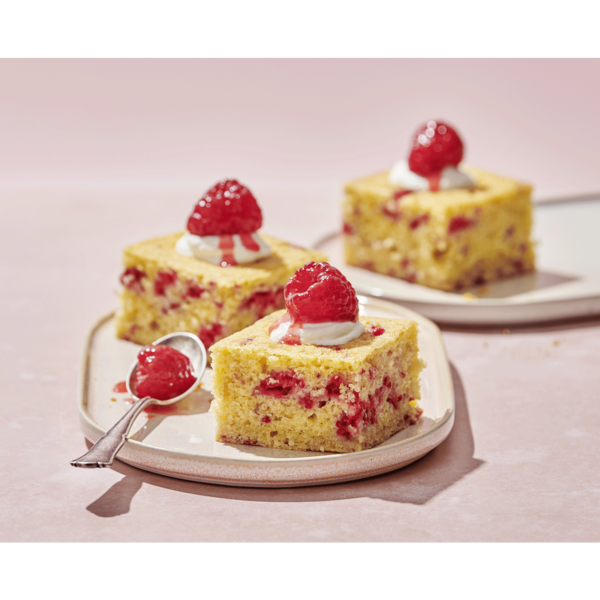 Himbeerkuchen mit Sahne und Himbeersauce auf einem Teller, Nahaufnahme