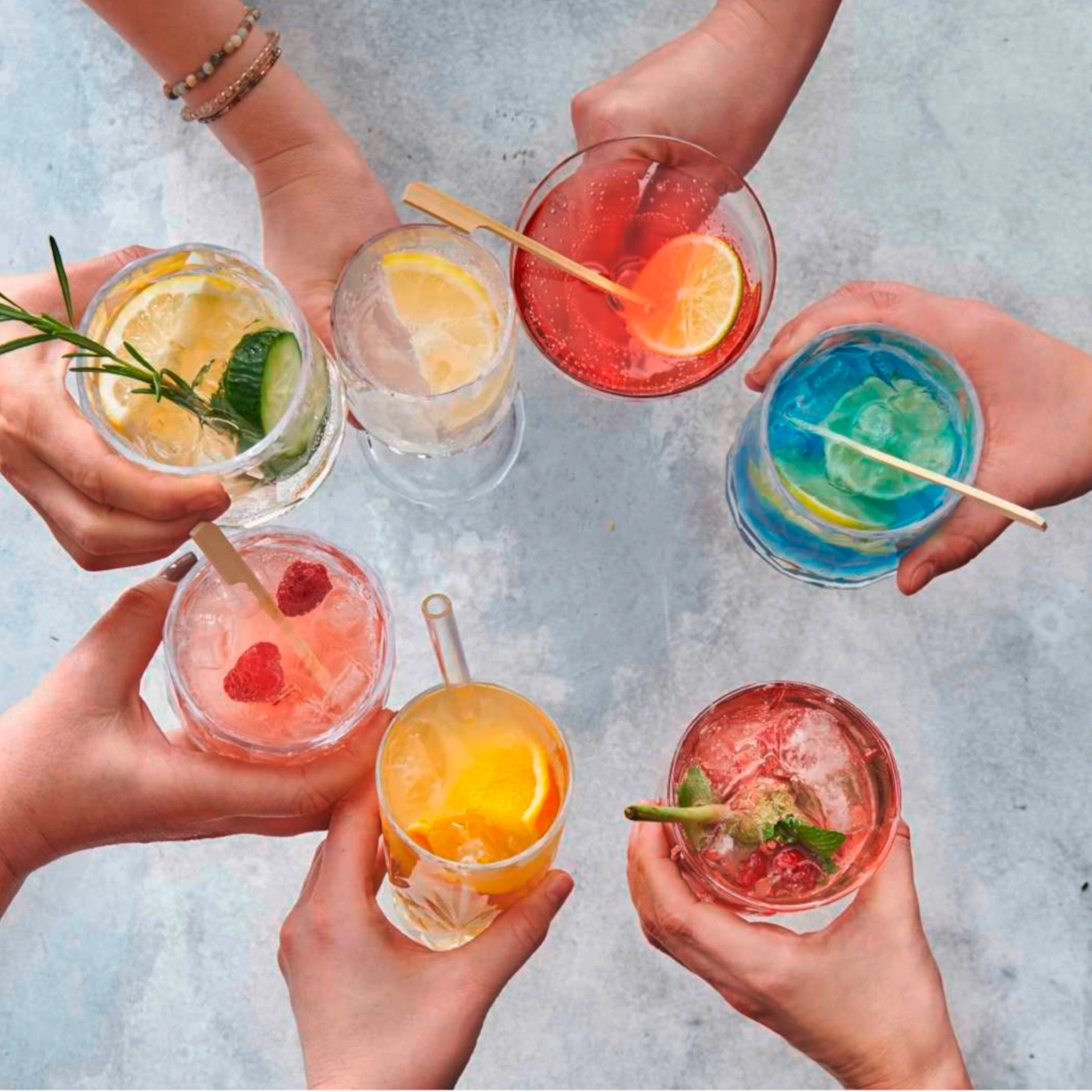 Hände halten Cocktails. Verschiedene Getränke mit Früchten und Kräutern. Sommergetränke.