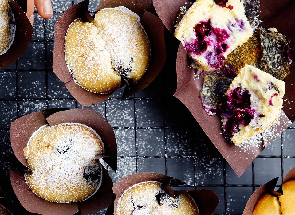 Blaubeermuffins mit Puderzucker auf einem Gitter, Nahaufnahme, lecker, Gebäck