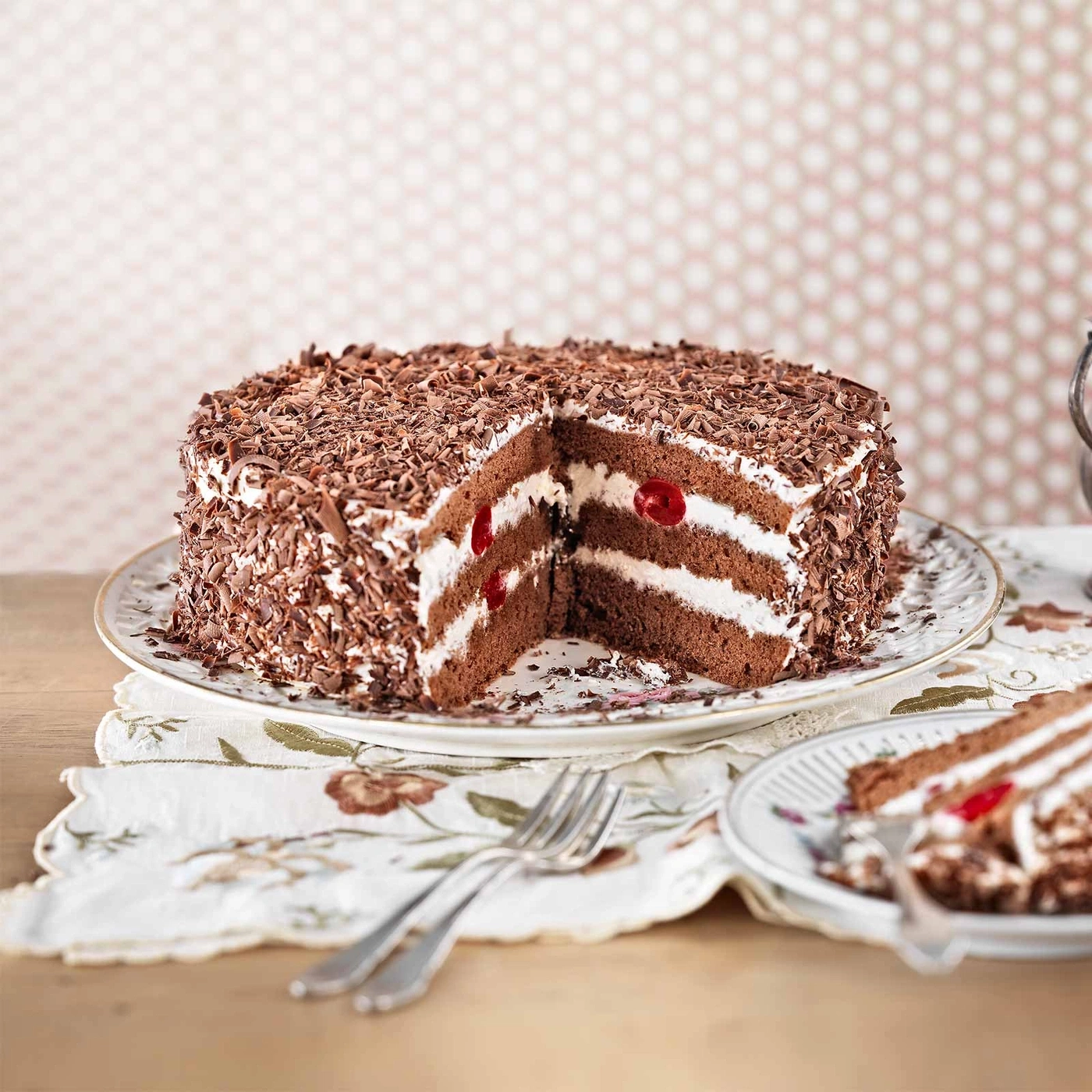 Schwarzwälder Kirschtorte auf einem Teller mit einer Gabel und einem Stück Kuchen.