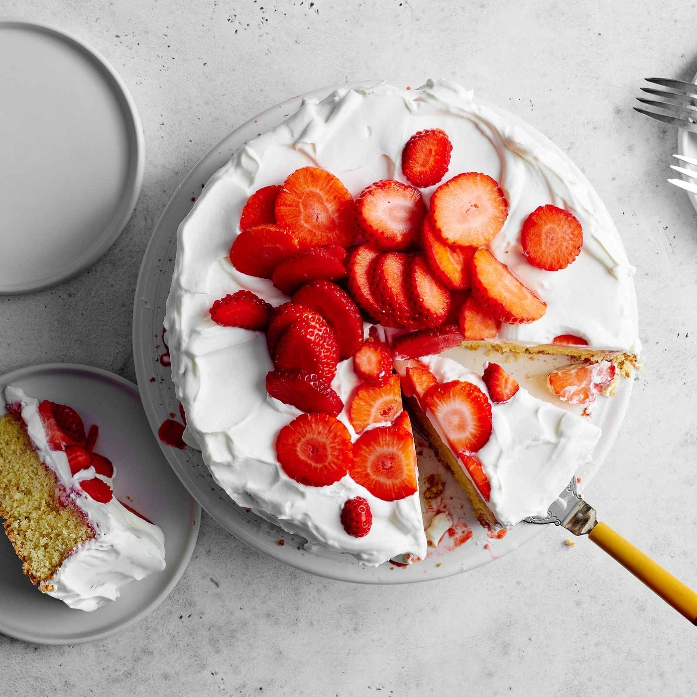 Erdbeerkuchen mit Sahne, auf einem Teller, ein Stück wird serviert
