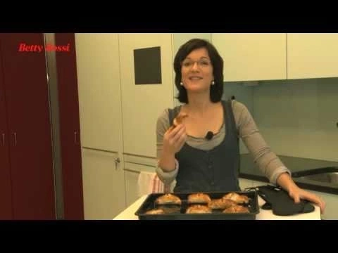 Frau hält Gebäck in der Küche, Backblech mit Gebäck, Betty Bossi Logo