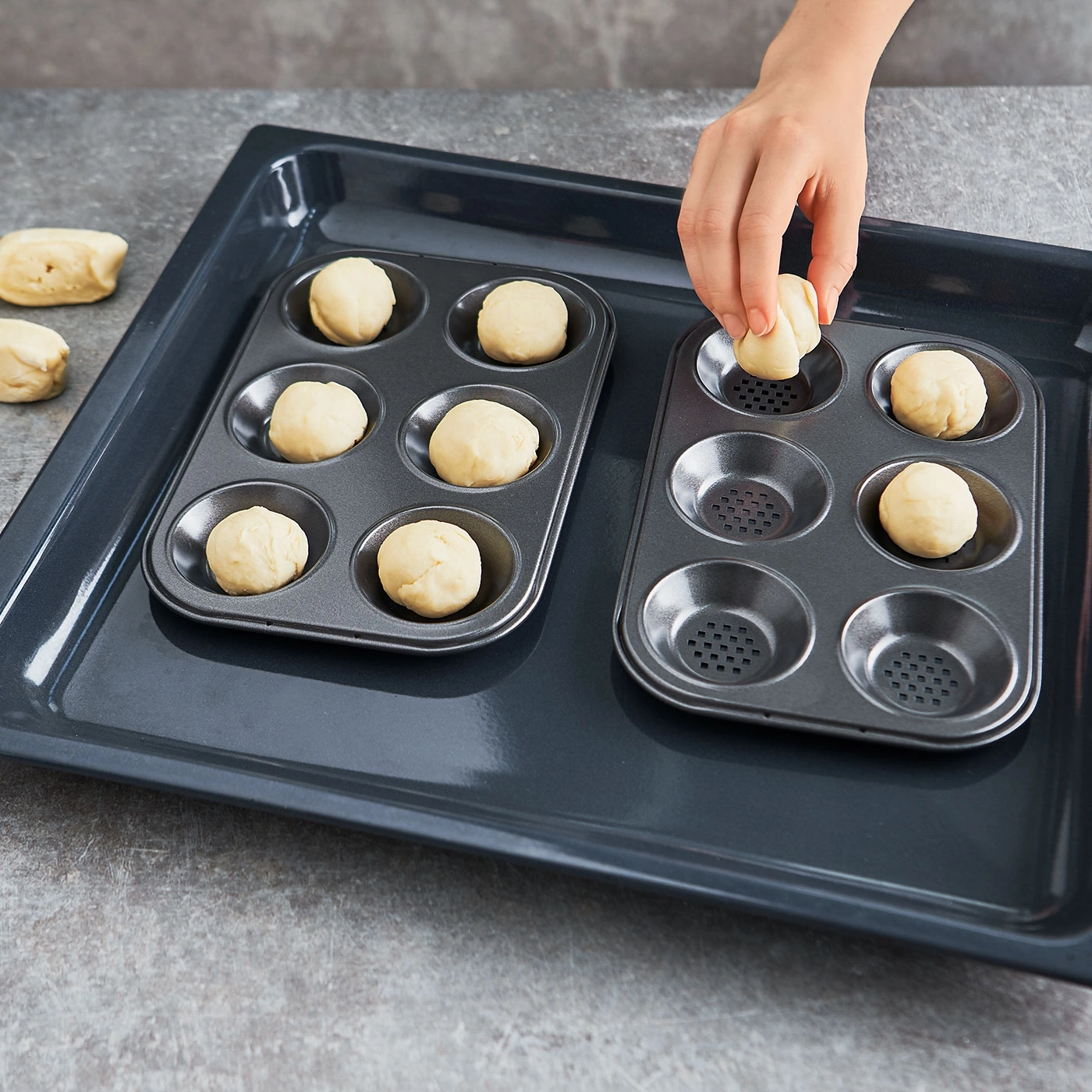 Personne place des boules de pâte dans un moule à pâtisserie sur une plaque
