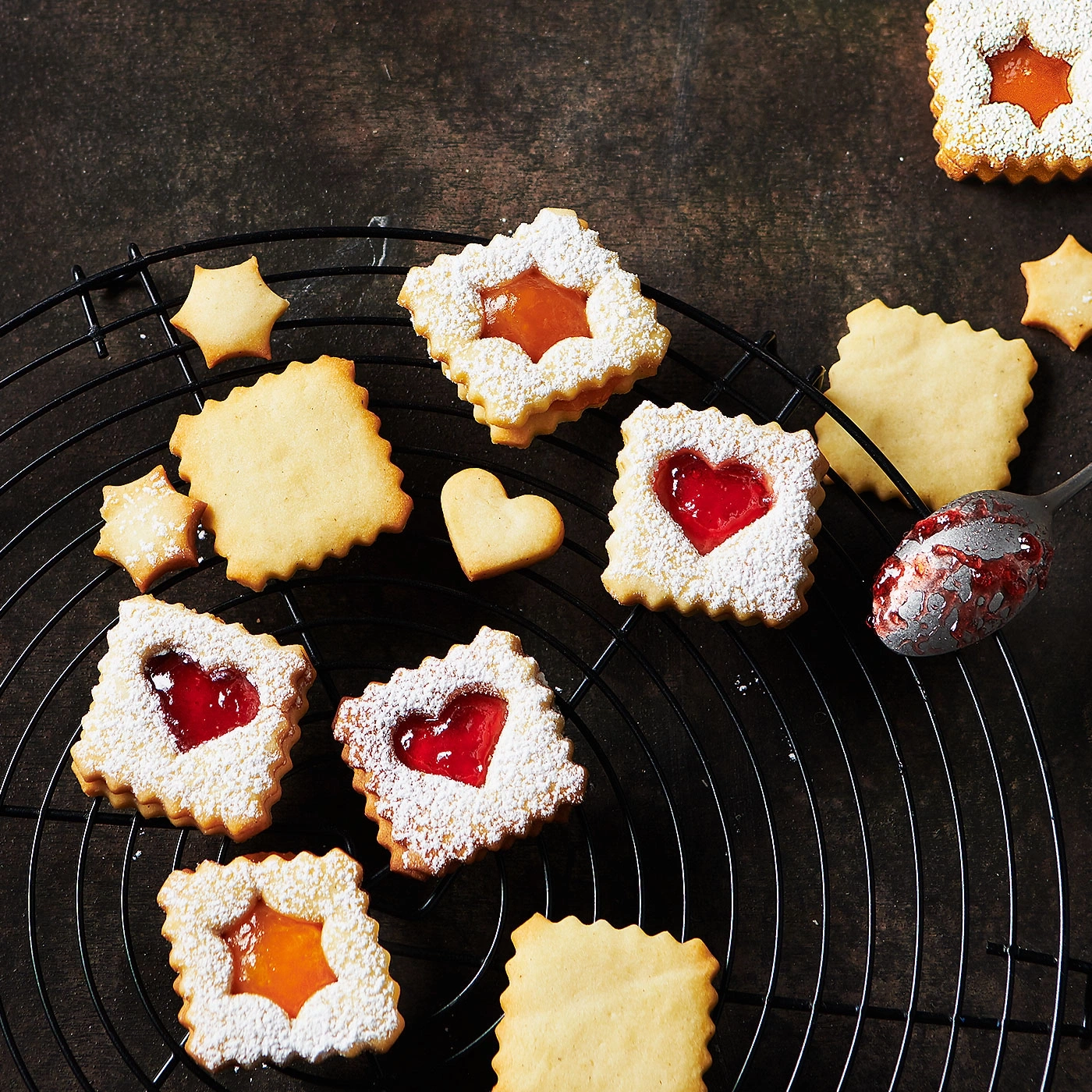 Biscuits à la confiture sur une grille noire, sucre glace, forme d'étoile, forme de cœur