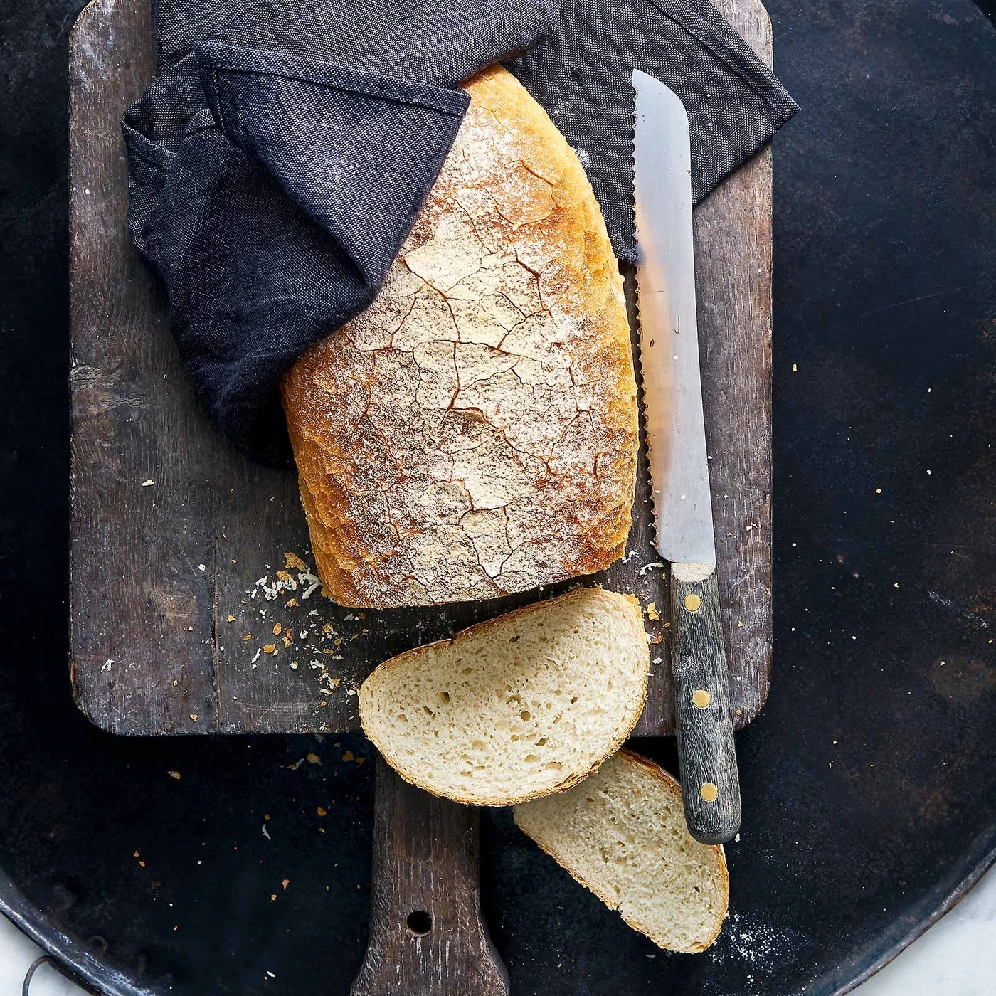 Brot auf Holzbrett mit Messer und Tuch, rustikal, lecker, frisch
