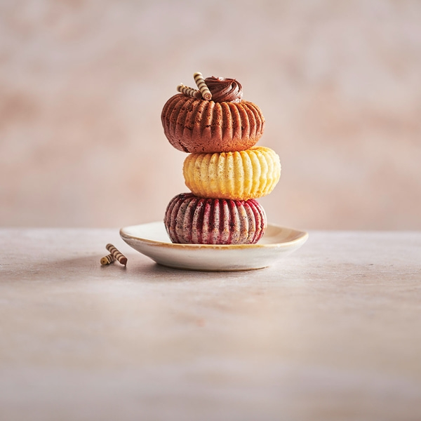Gestapelte Kuchen auf einem Teller mit Schokoladenverzierung und Dekoration.