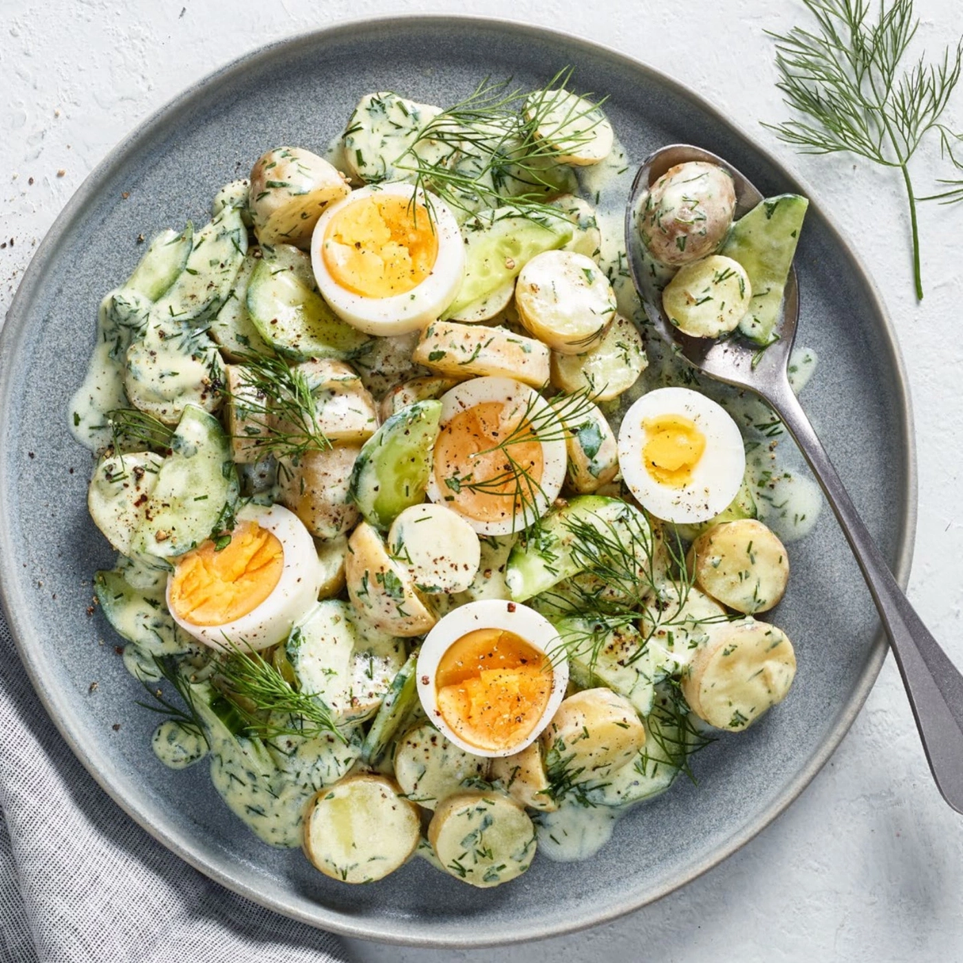 Salade de pommes de terre avec œufs, concombres et aneth dans une assiette