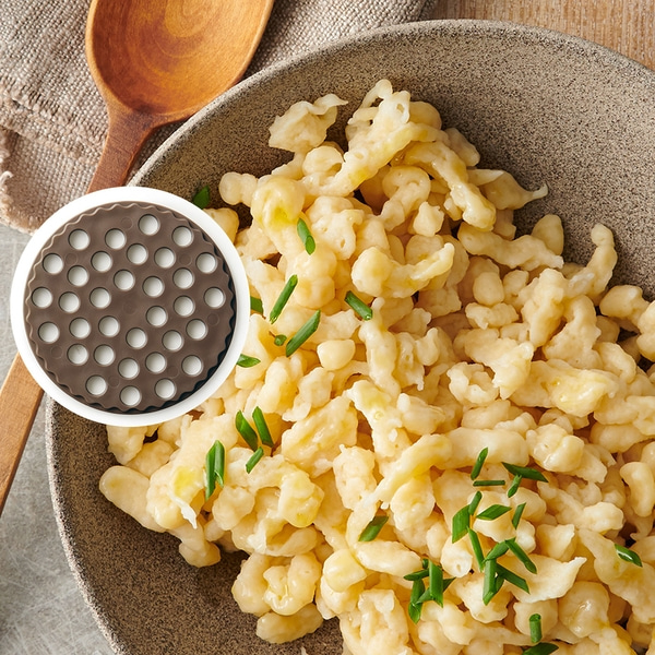 Gros plan de spaetzle avec de la ciboulette dans un bol, ustensile de cuisine