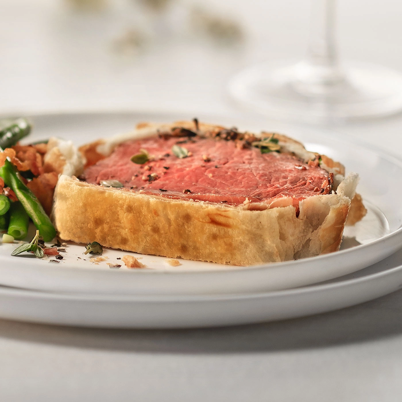 Filet Wellington mit Beilagen auf einem weißen Teller, Nahaufnahme