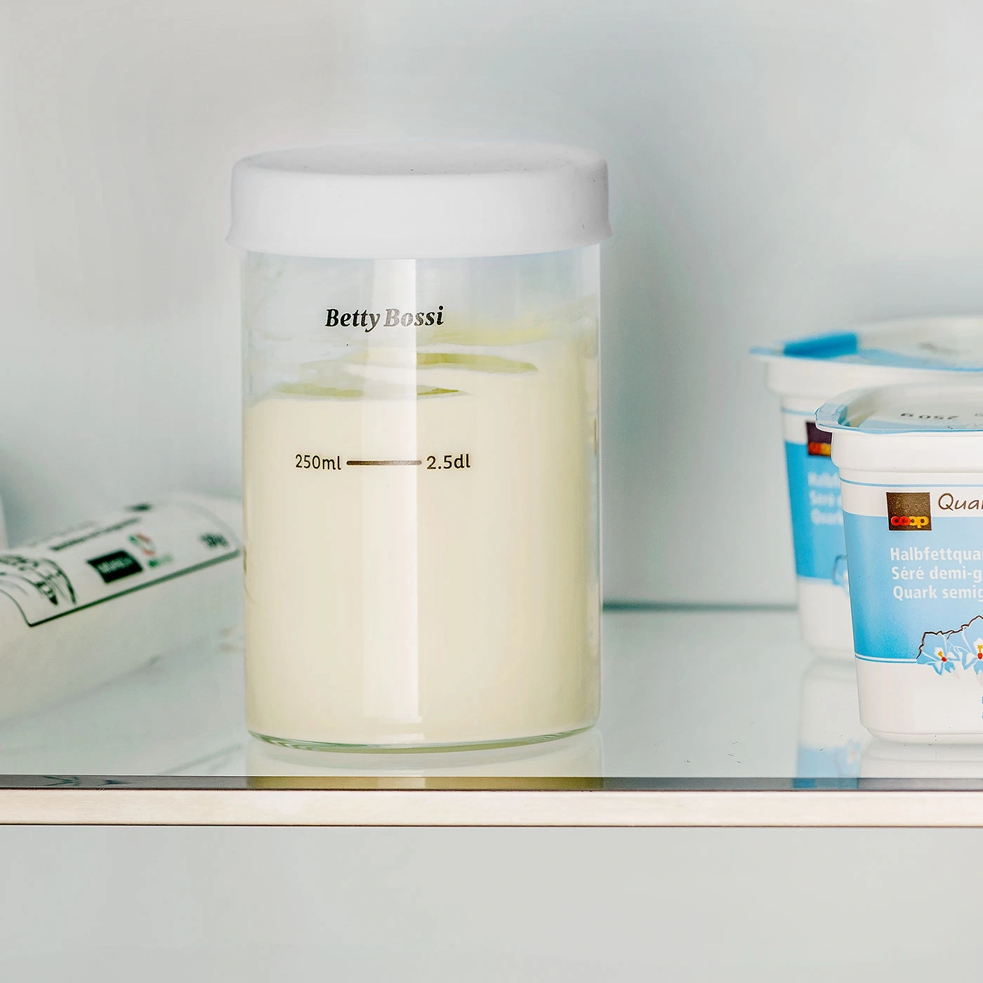 Milchbehälter im Kühlschrank mit Betty Bossi-Logo und Quark-Bechern.