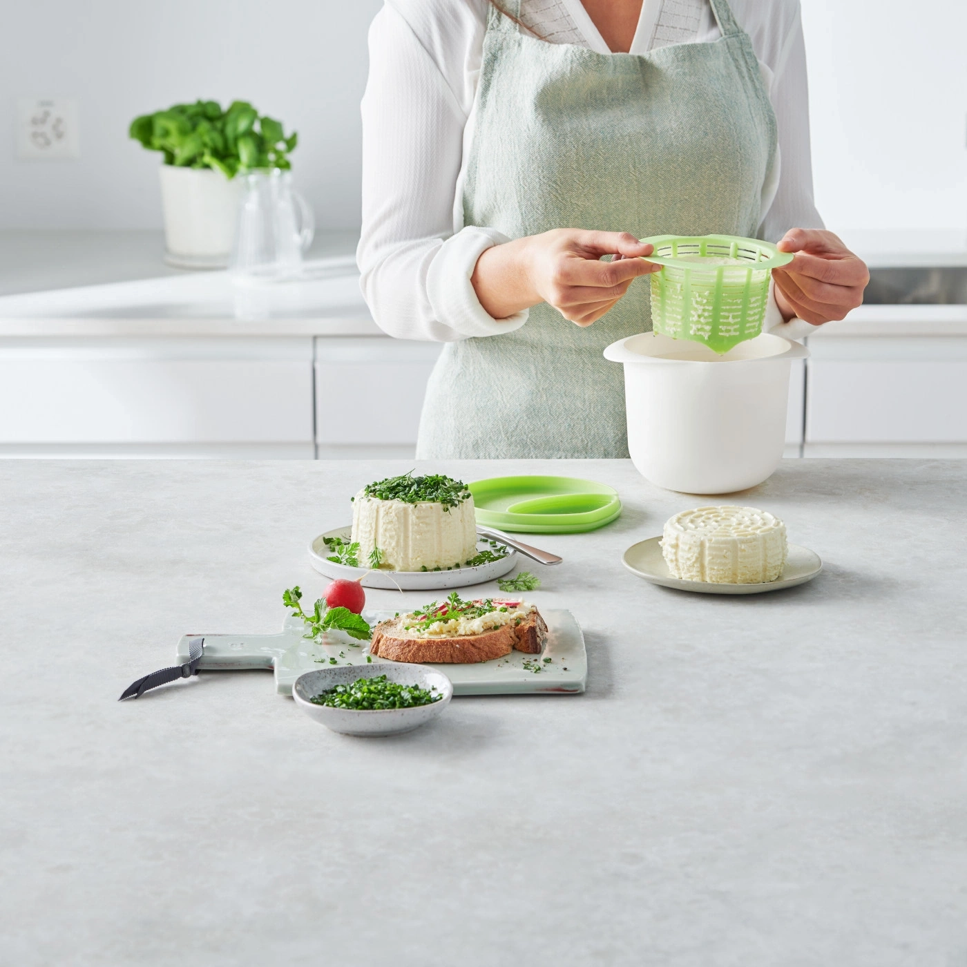 Femme prépare du fromage. Fromage, herbes, pain sur la table.
