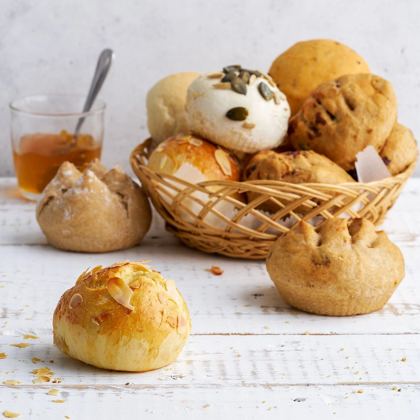 Korb mit Brötchen, Glas mit Marmelade, Holzuntergrund, Nahaufnahme, Essen