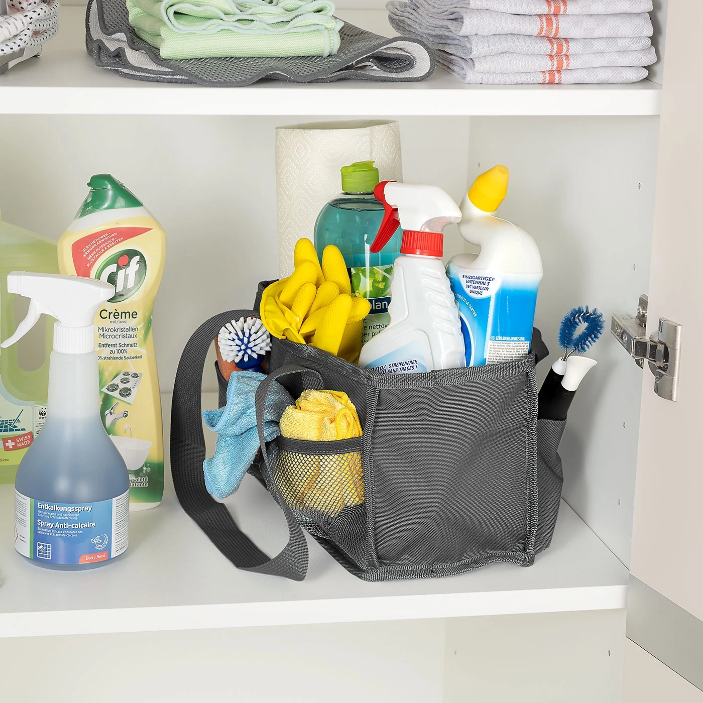 Reinigungsmittel in einem Schrank. Sprays, Schwämme, Bürsten und Handschuhe.