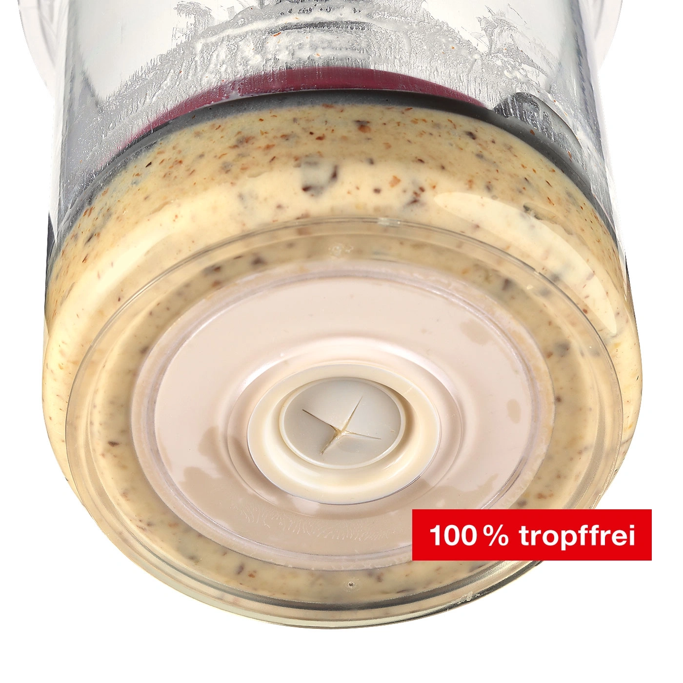 Nahaufnahme eines Mixbehälters mit cremiger Sauce, Text '100 % tropffrei'.