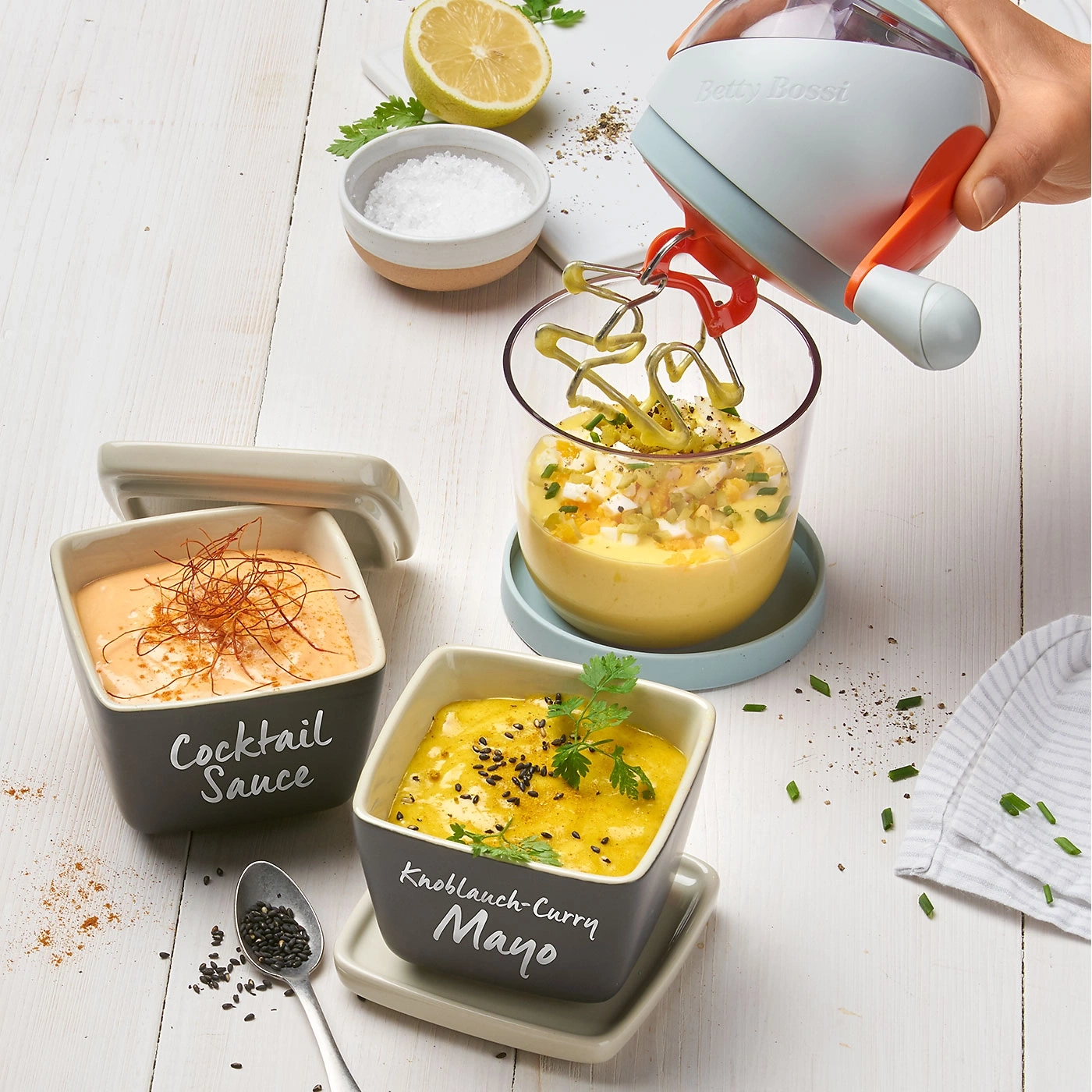 Diverses sauces et un mixeur sur une table en bois blanche. Délicieux!