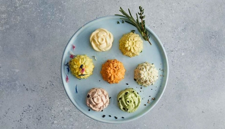 Teller mit bunten Butterblumen, Kräutern und Gewürzen, Nahaufnahme