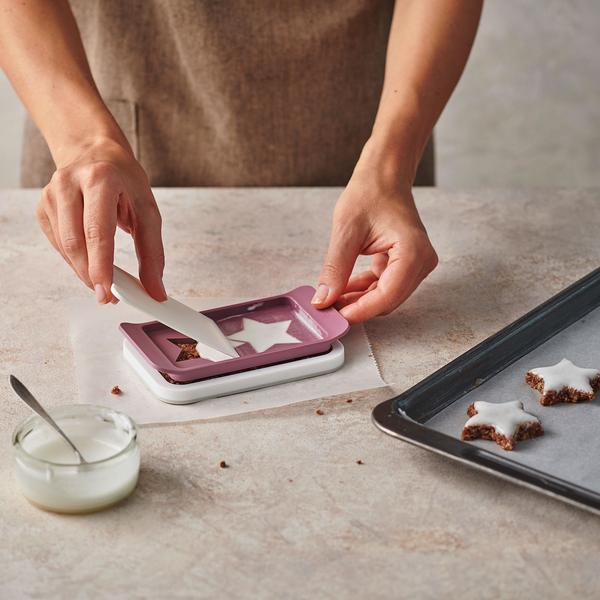 Person verziert Sternkekse mit Zuckerguss, Backen, Küche, Nahaufnahme, Hände