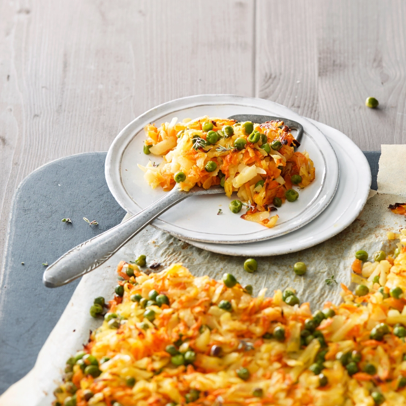 Gemüseauflauf mit Erbsen auf Tellern und Backpapier