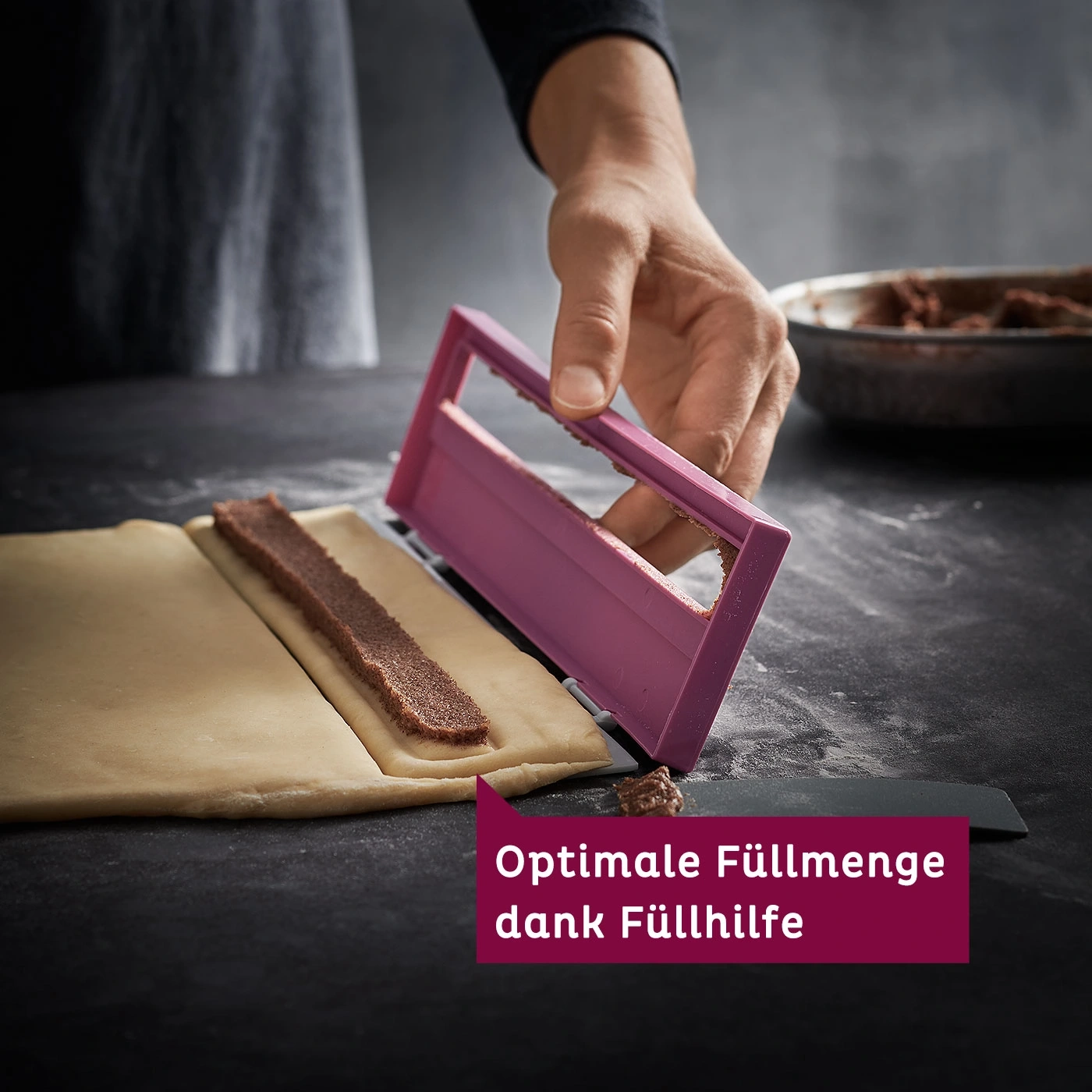 Person verwendet ein pinkfarbenes Werkzeug, um Gebäck zu füllen, mit Text auf einem roten Banner.