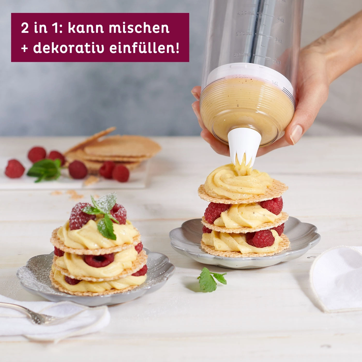 Dessert avec framboises et crème, décoré de menthe, sur une assiette.