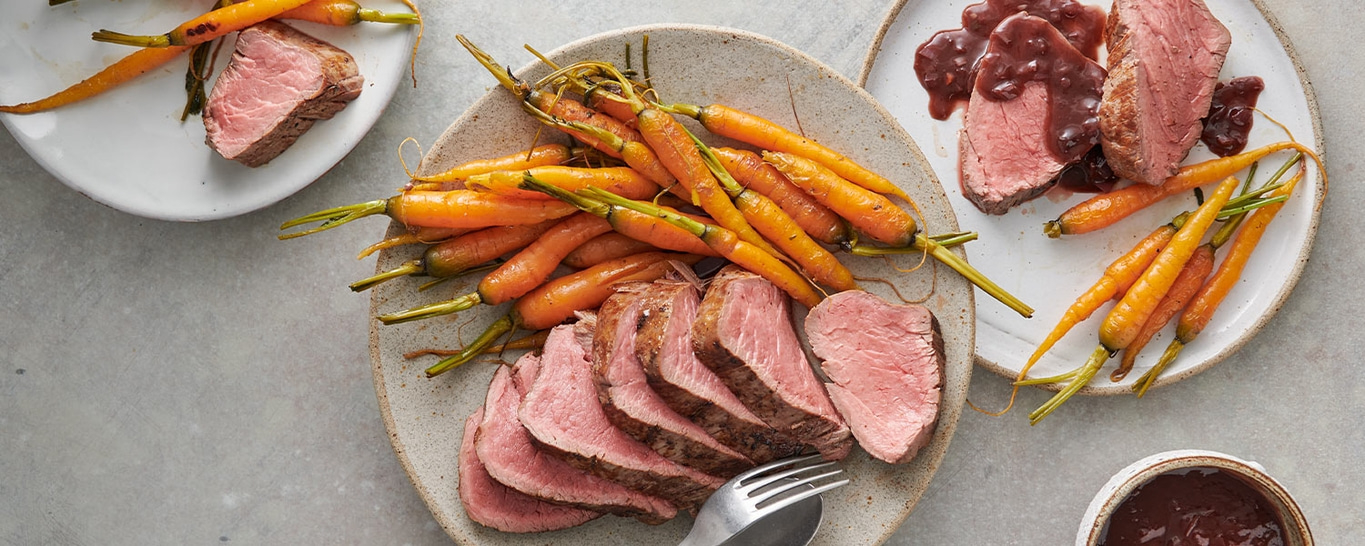 Viande rôtie avec carottes et sauce sur des assiettes