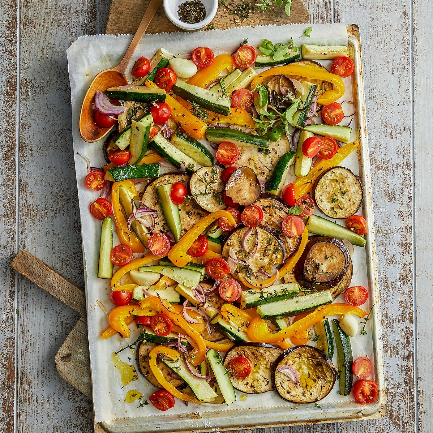 Légumes rôtis sur une plaque de cuisson avec tomates et herbes aromatiques