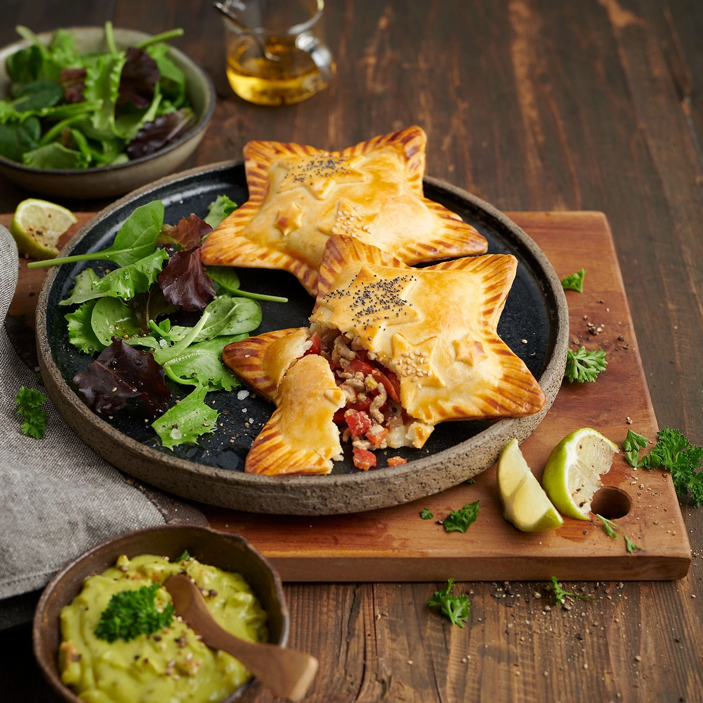 Pâtés en forme d'étoile avec salade et trempette d'avocat sur planche de bois