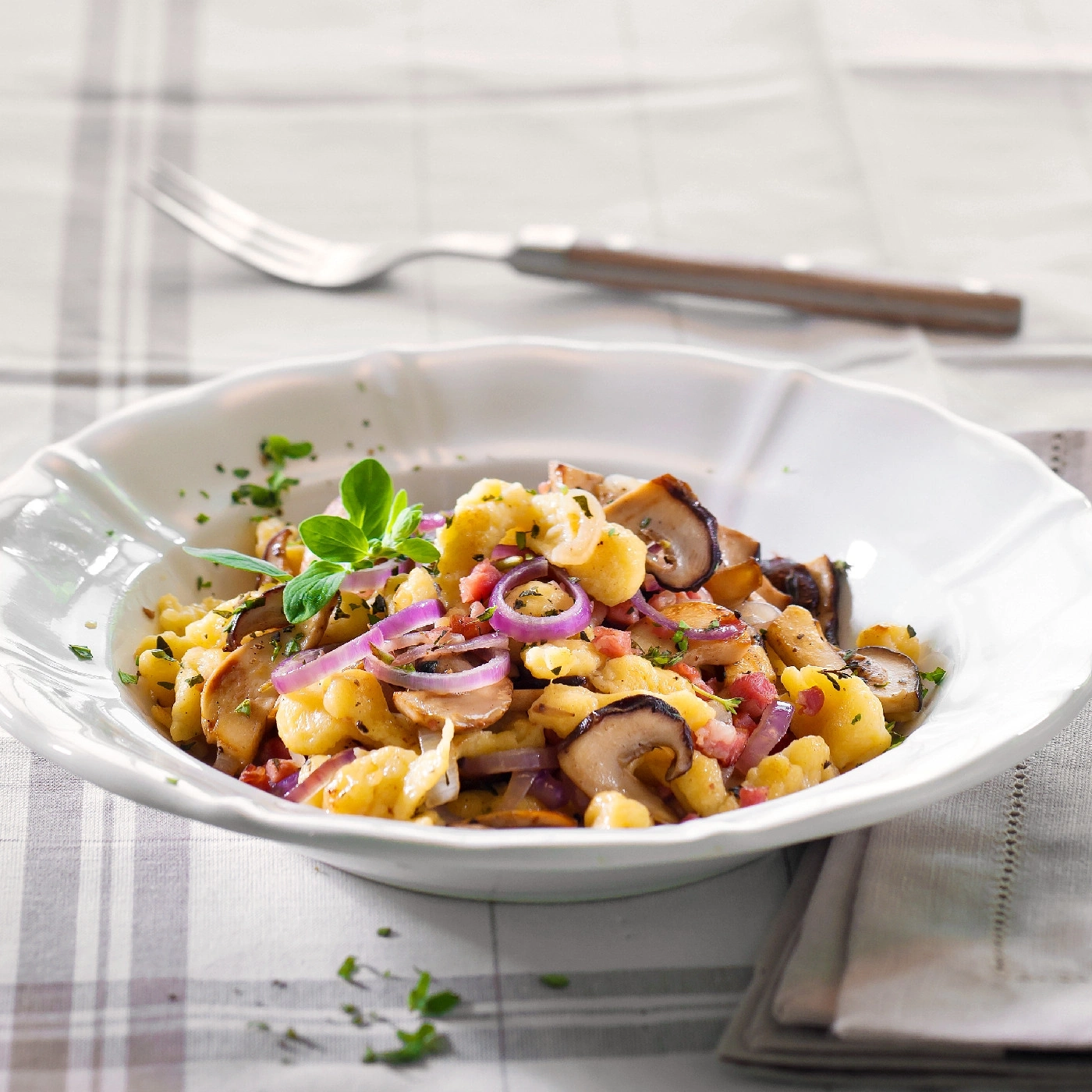 Leckeres Gericht mit Pilzen, Zwiebeln und Kräutern in einer Schüssel.