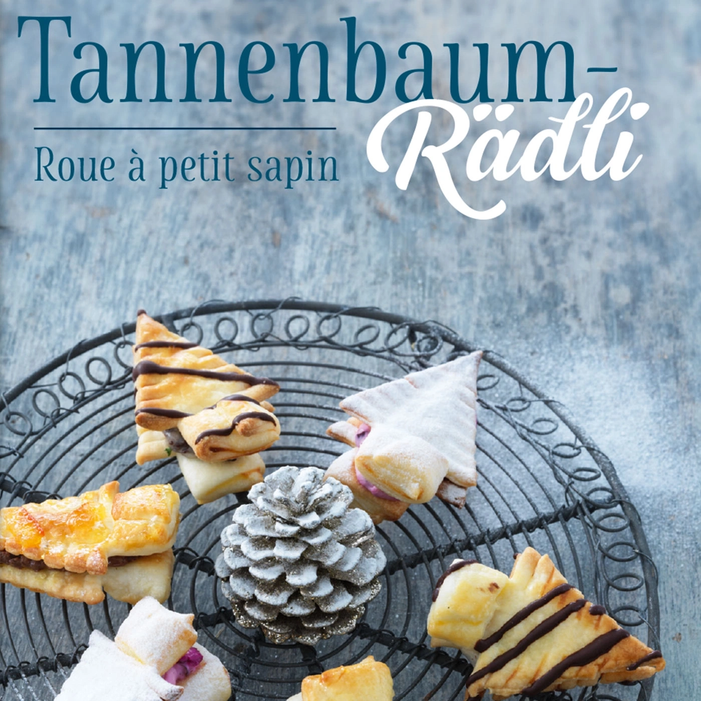 Weihnachtsplätzchen in Tannenbaumform auf einem Drahtgestell mit Tannenzapfen.