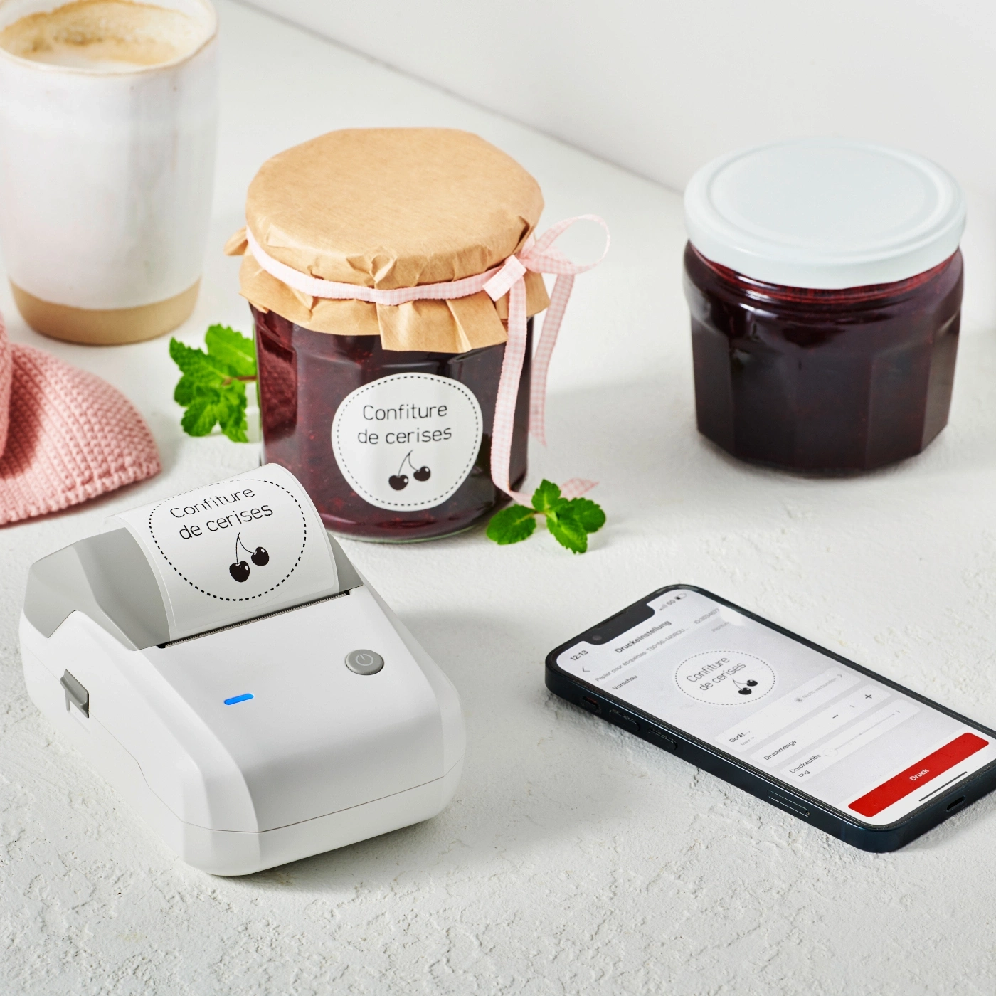 Imprimante d'étiquettes, smartphone, pots de confiture, autocollants, café, cerises, confiture.