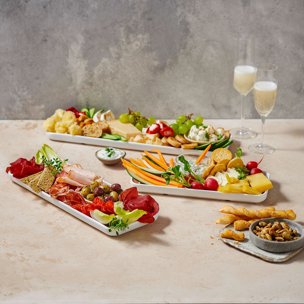 Plateaux de fromages avec champagne, légumes et collations sur une table