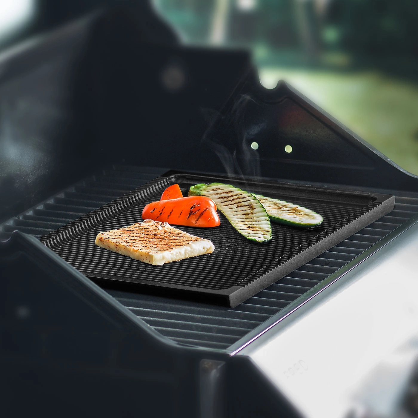 Gemüse und Käse auf einem Grillrost. Gegrilltes Essen. Sommerliche Mahlzeit.