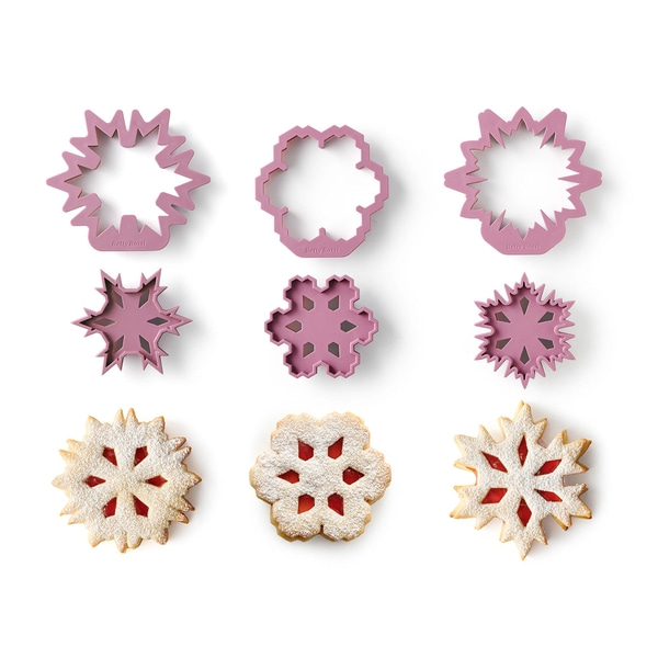 Emporte-pièces et biscuits en forme de flocons de neige sur fond blanc. Pâtisserie, Noël.