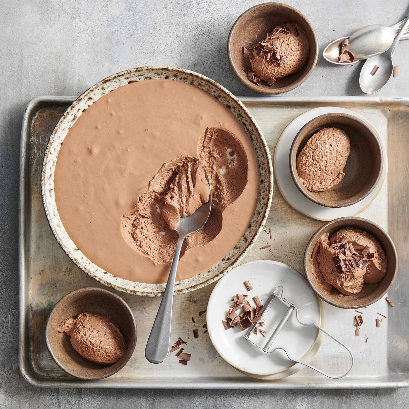 Schokoladenmousse in Schalen und Schüssel, mit Schokoladenraspeln und Löffel