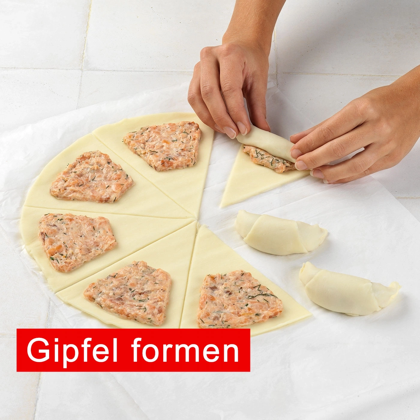 Hände formen Gipfel mit Lachs auf Teig, auf Backpapier, Nahaufnahme