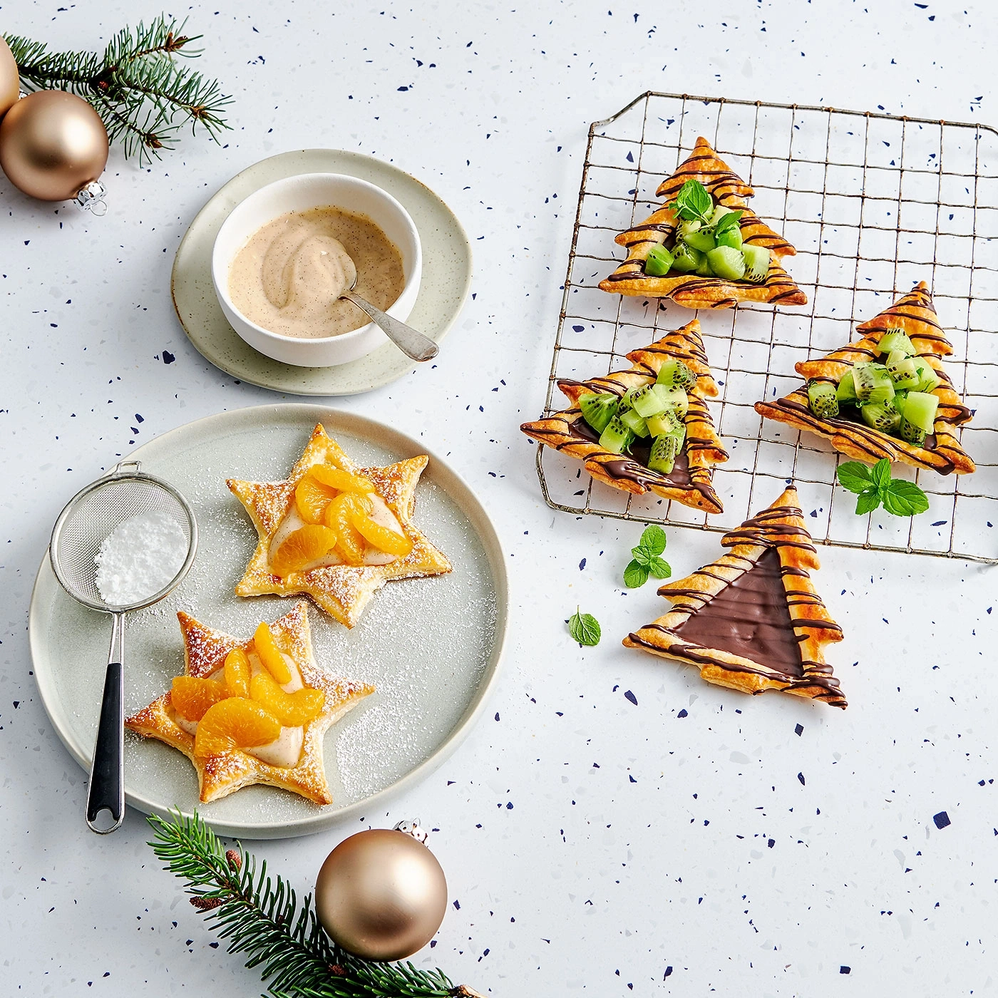 Pâtisseries de Noël avec fruits et chocolat décorées sur une table festive.
