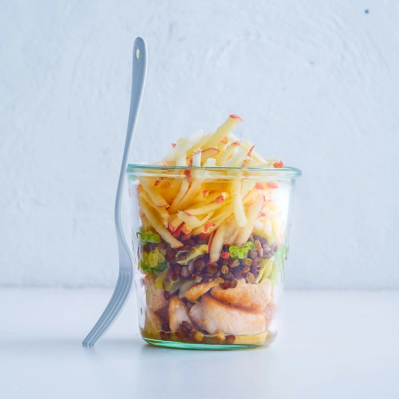 Salat im Glas mit Apfel, Linsen und Hähnchen, mit Gabel