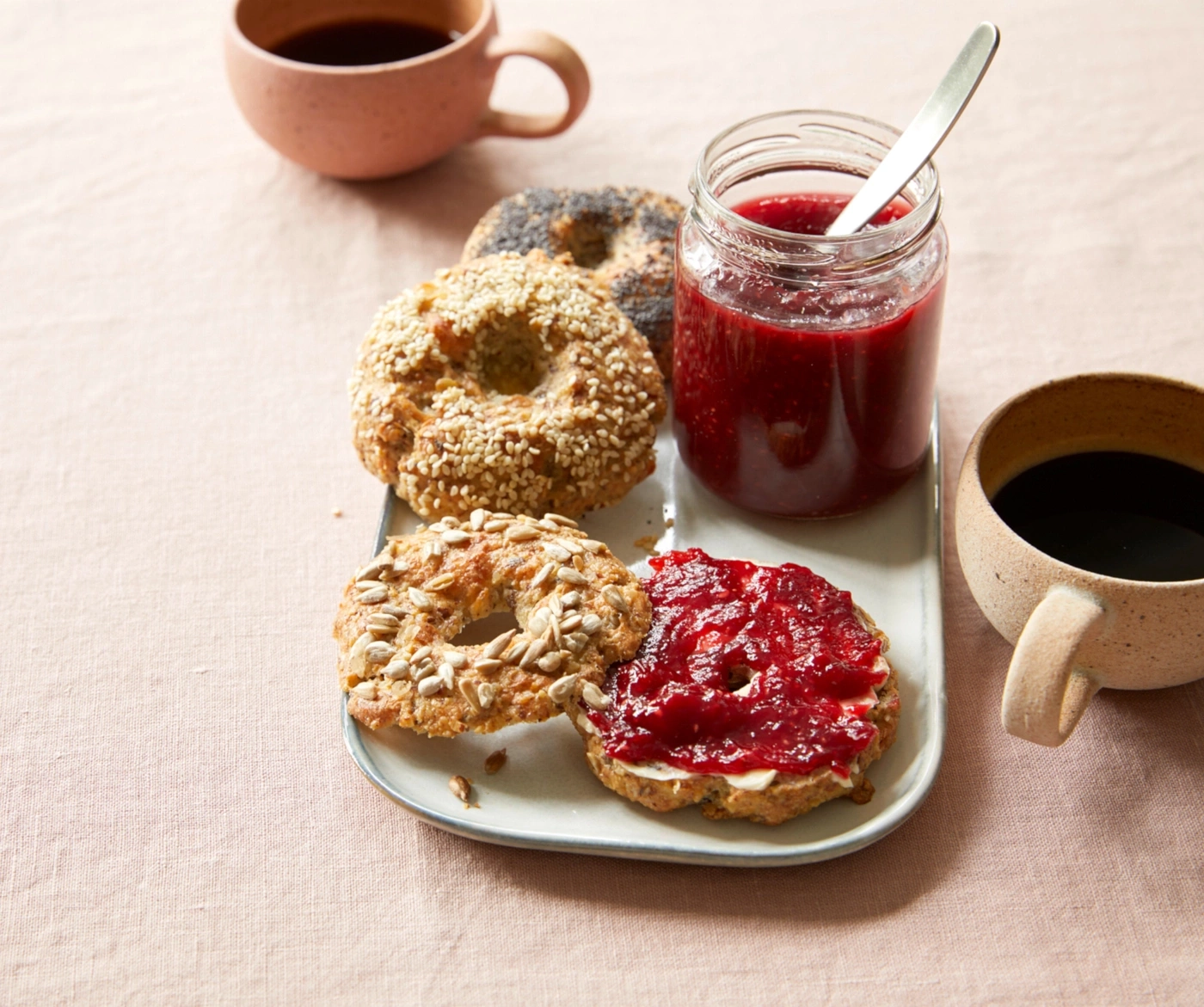 Frühstück mit Bagels, Marmelade und Kaffee auf einem Tisch