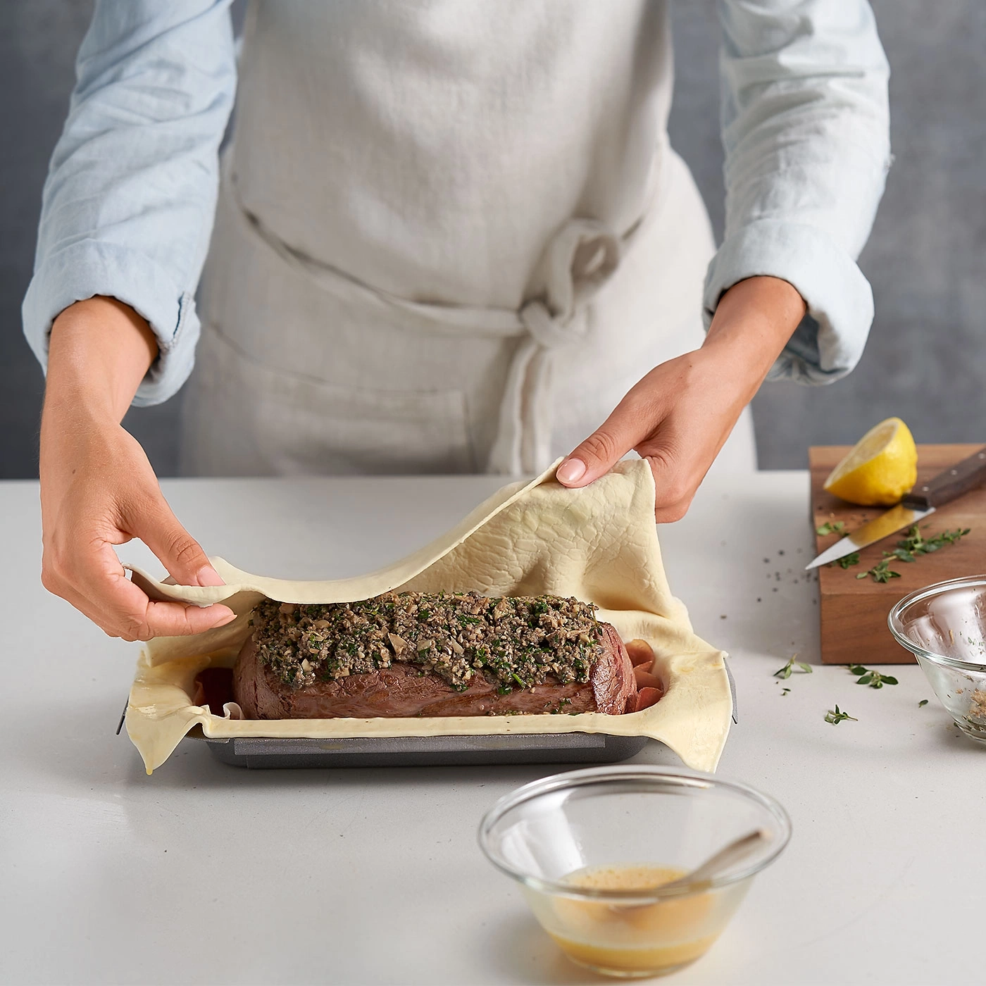 Person umhüllt Fleisch mit Teig. Zubereitung von Wellington. Küche, Kochen, Essen.
